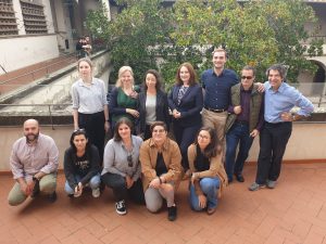 A group of participants posing in front of a green space