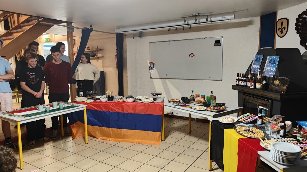 Four tables full of traditional foods and drinks, decorated with national flags