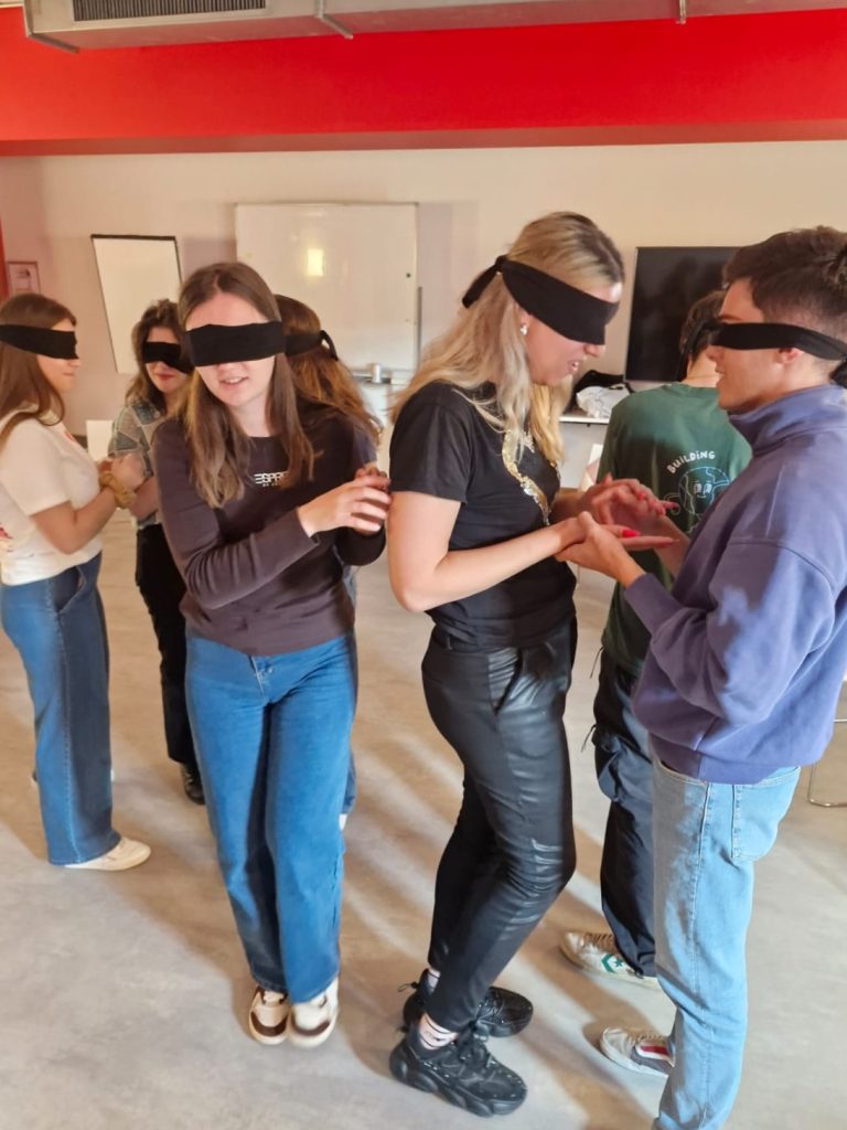 Patricia and other blindfolded participants during an activity, moving around the space blindfolded