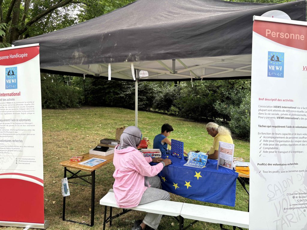 The VIEWS International gazebo with the VIEWS vertical banners. children and VIEWS volunteers are playing under the gazebo.