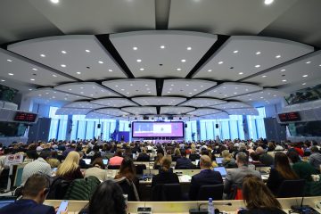 Conference room during the opening session, framed from the entrance